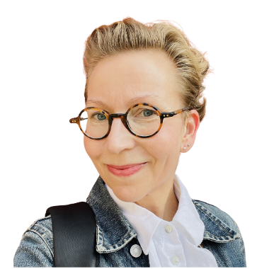 Hanna Dufvalla on farkkutakki,  alla valkoinen paita, olkapäällä reppu. Hannalla on silmälasit ja lyhyet hiukset. Hän hymyilee. 